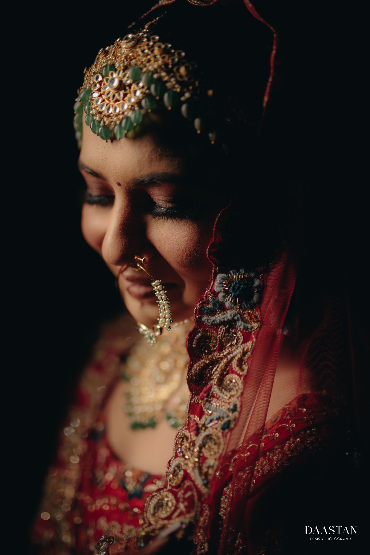 Detailed close-up of Indian bride's face with maang tikka, nose ring and kohl eyes, wedding photography