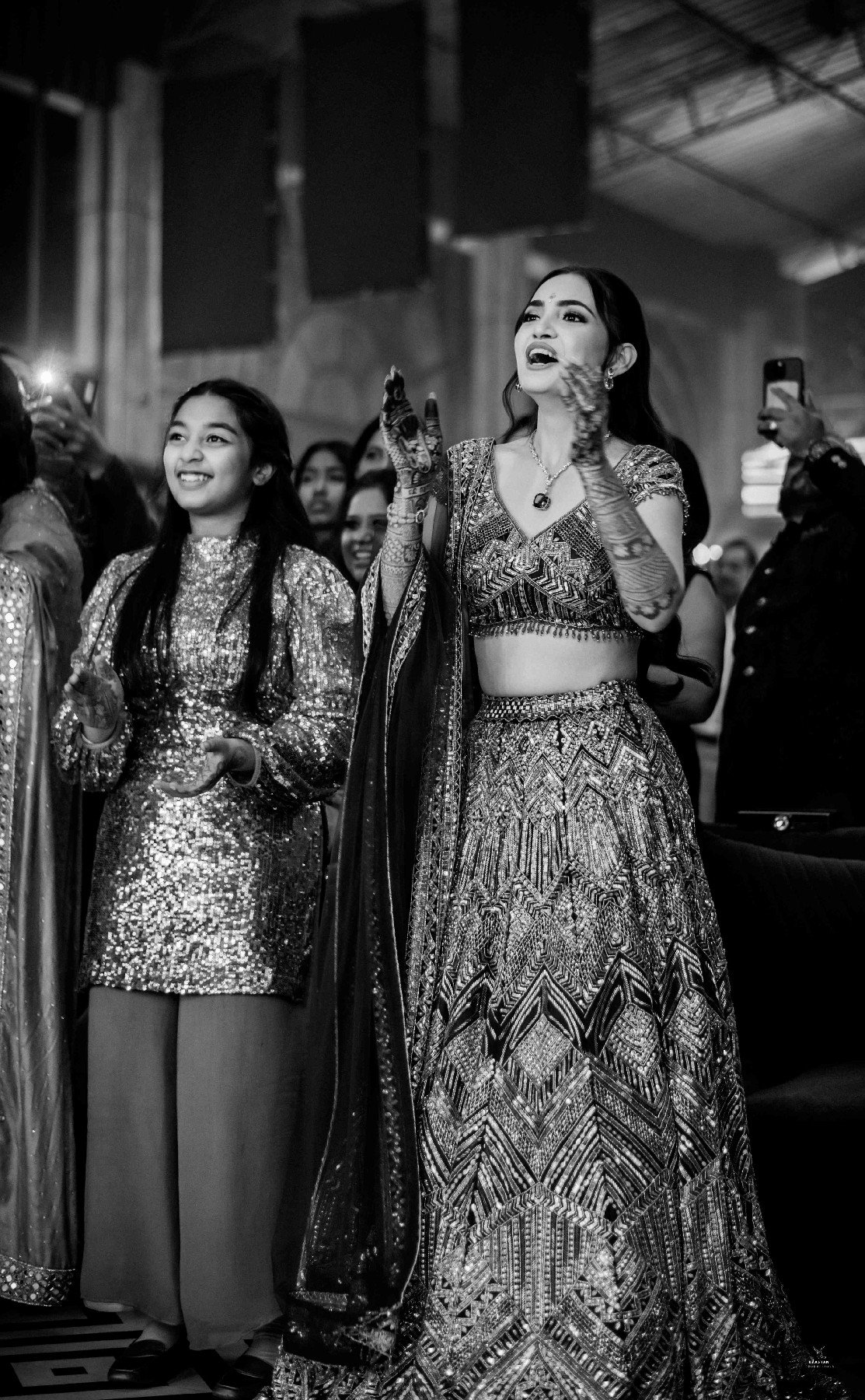 Monochrome candid of bride joyfully dancing at reception, artistic wedding photography by production house