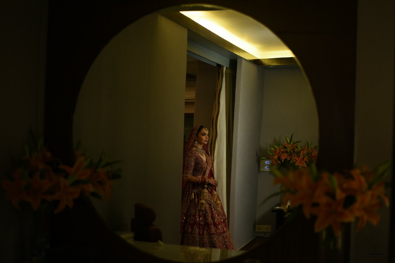 Bride captured in ambient floral-lit hotel corridor, candid wedding photography by Indian production house