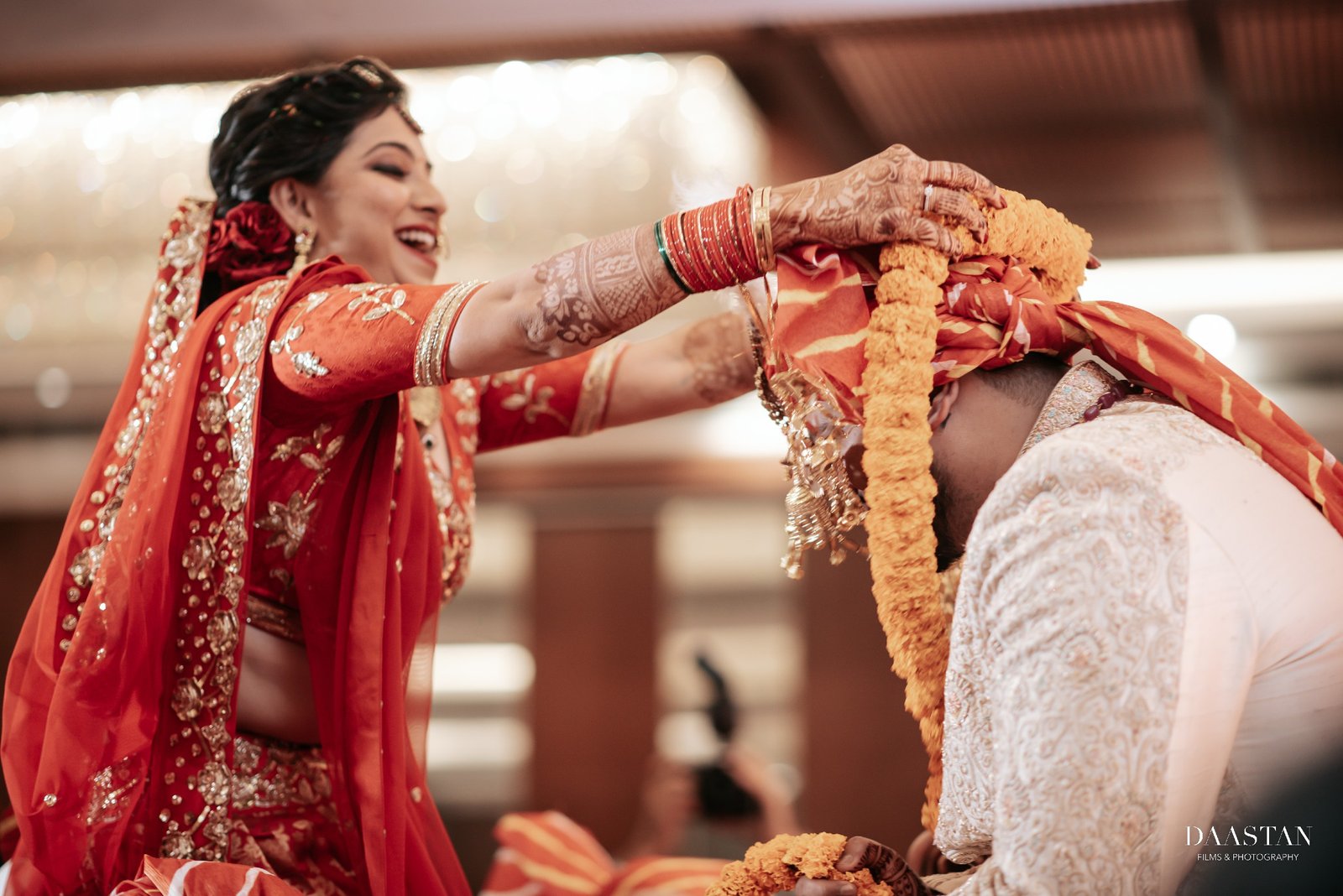 Bride placing garland on groom during jaimala ceremony, candid Indian wedding photography