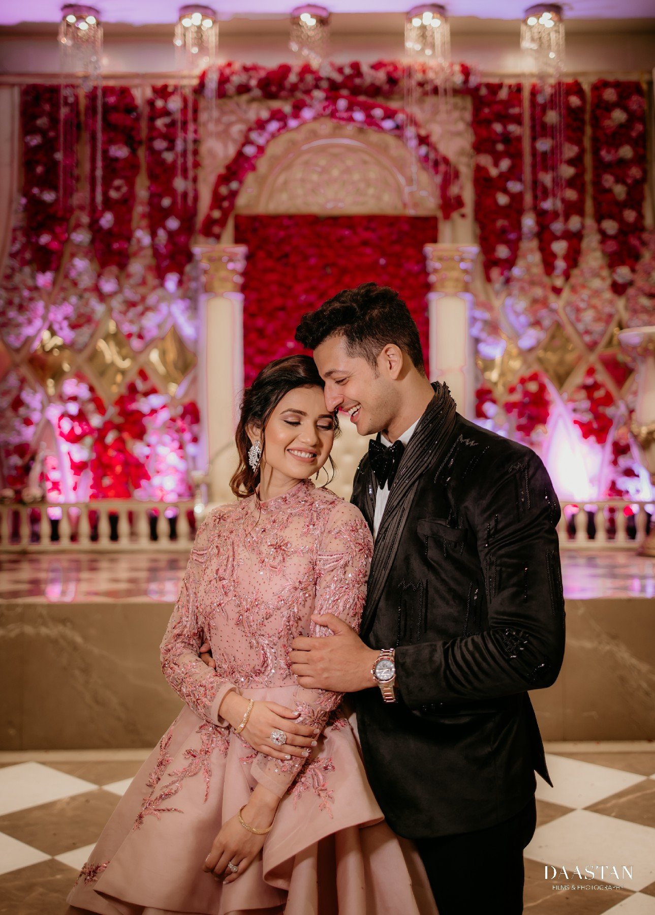 Couple in matching blush reception outfits, elegant portrait by Indian wedding production house
