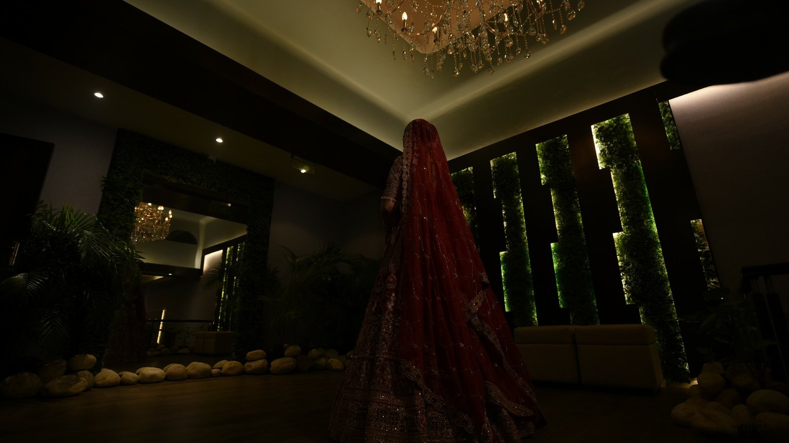 Dramatic low-angle cinematic portrait of Indian bride in red lehenga, luxury wedding photography