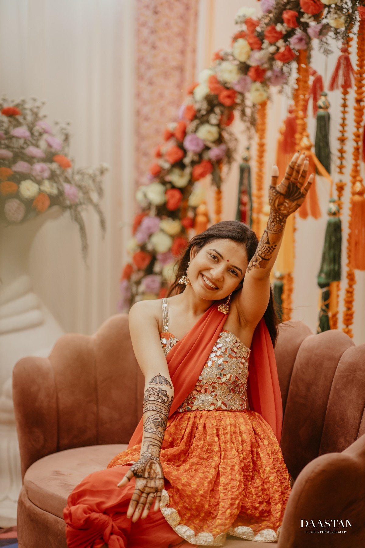 Bride smiling during mehendi ceremony with henna-adorned hands, candid Indian wedding photography