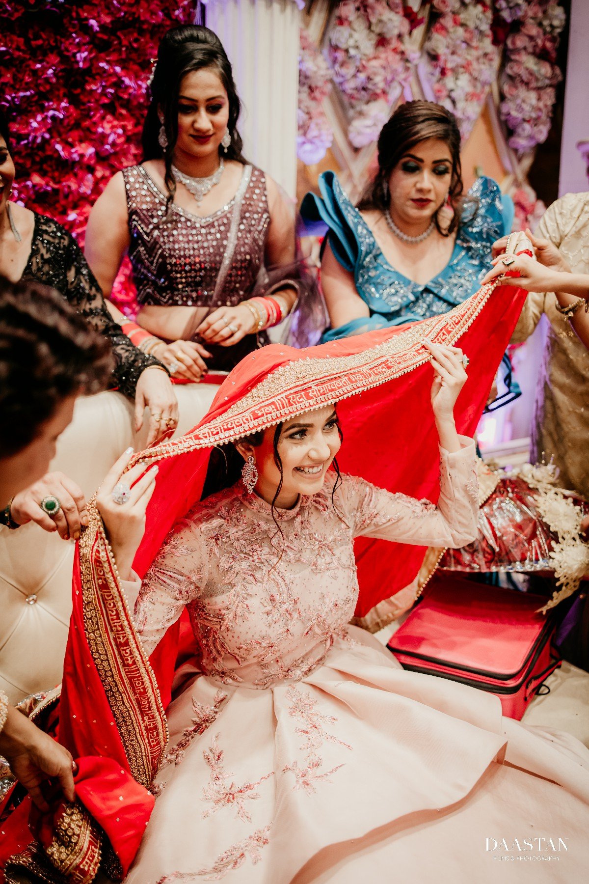 Bride in floral pink lehenga at Indian wedding reception, professional event photography