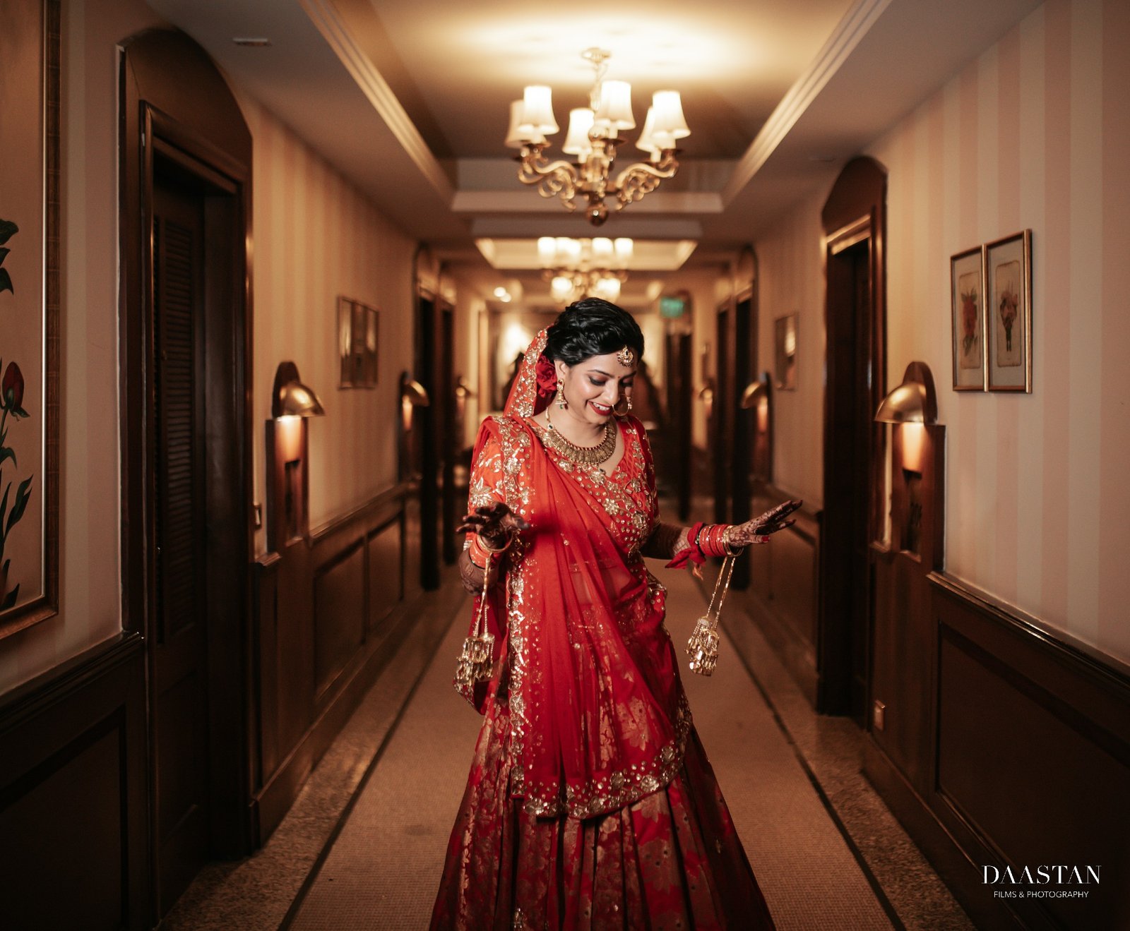 Bride in red lehenga walking through hotel corridor, cinematic entry shot Indian wedding photography