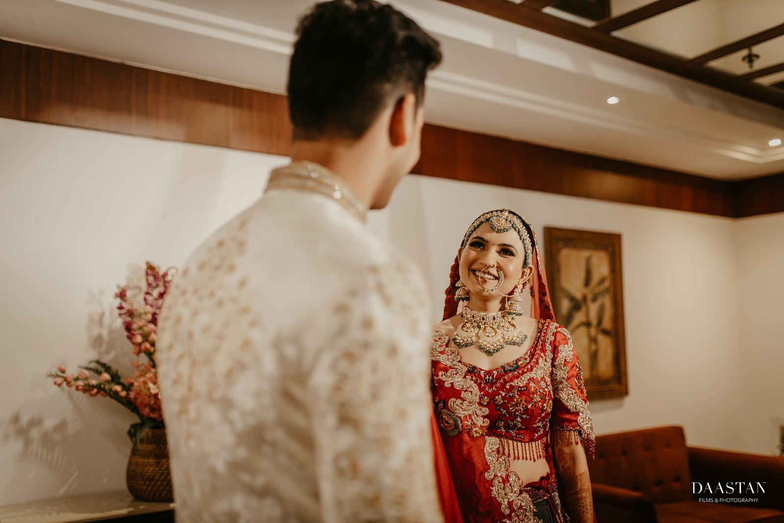 Bride in heavy embroidered red lehenga posing in luxury hotel corridor, cinematic wedding photography India