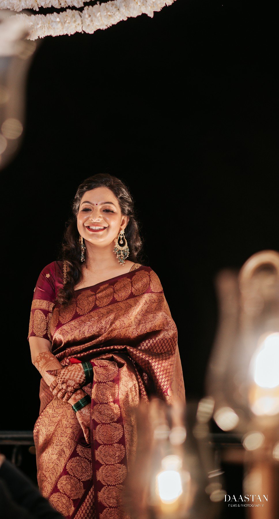 South Indian bride in vibrant red silk saree with gold jewellery, professional wedding portrait photography