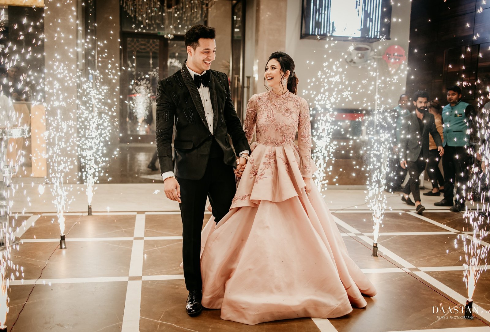 Couple making grand entrance with sparklers at wedding reception, cinematic wedding photography India