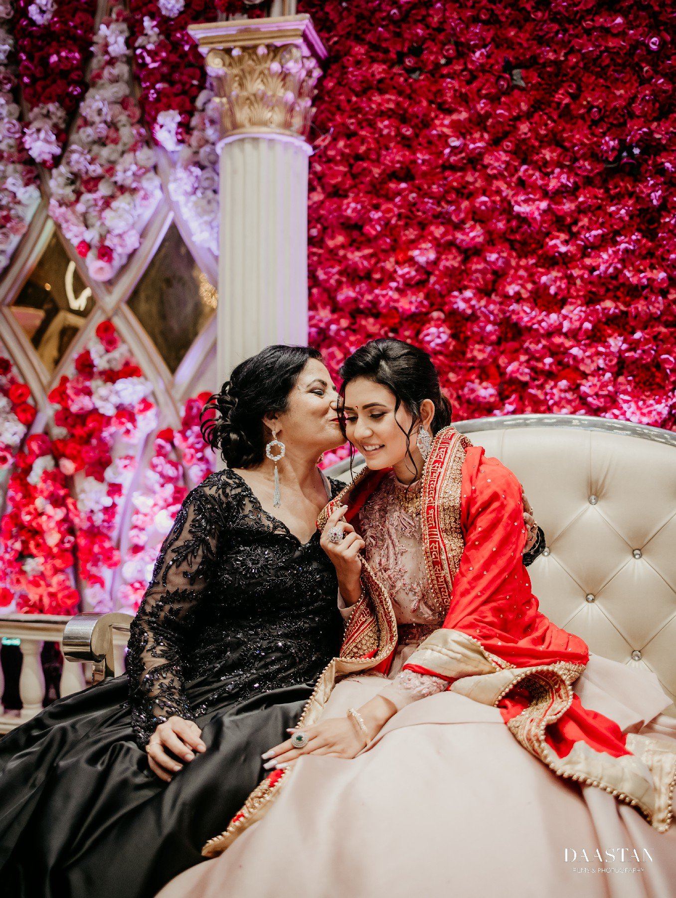 Romantic couple portrait in front of lush rose wall at Indian wedding reception