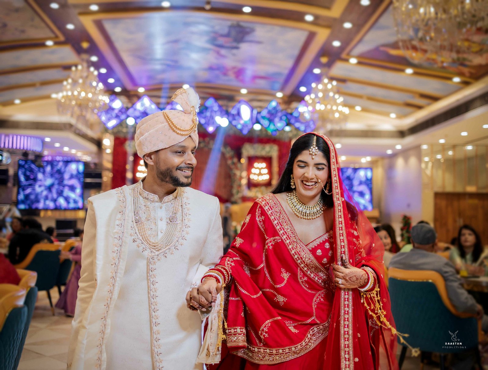Couple exchanging garlands during jaimala ceremony at decorated wedding venue, India