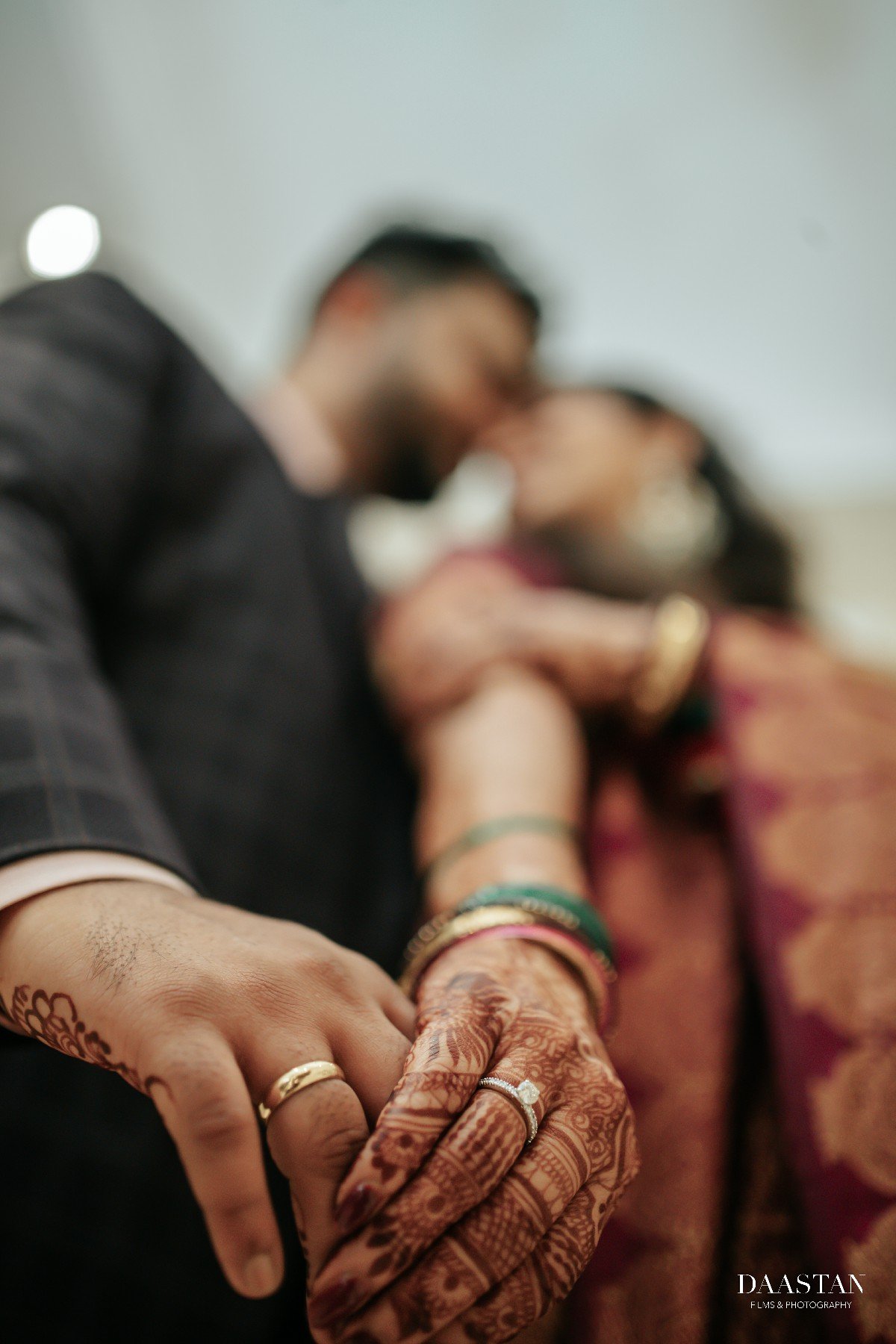 Intimate close-up of groom holding bride's hands with wedding ring, detail wedding photography India