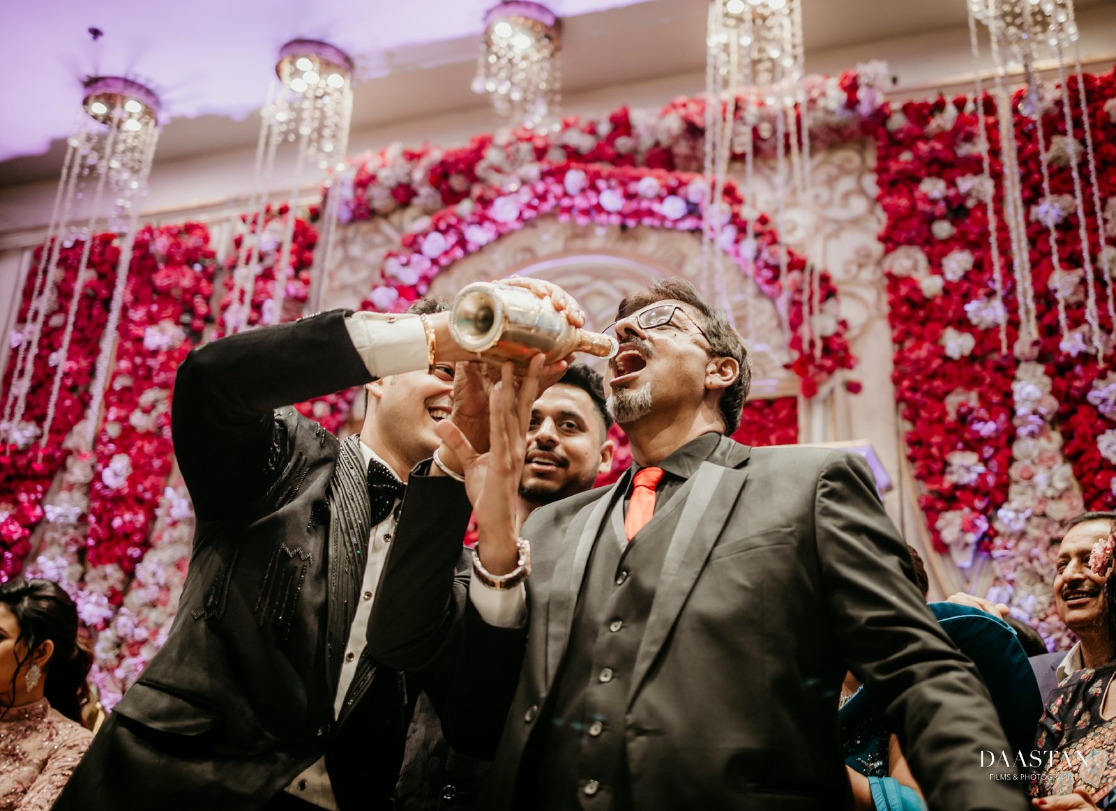 Groom celebrating with friends during confetti moment at reception, candid wedding photography India