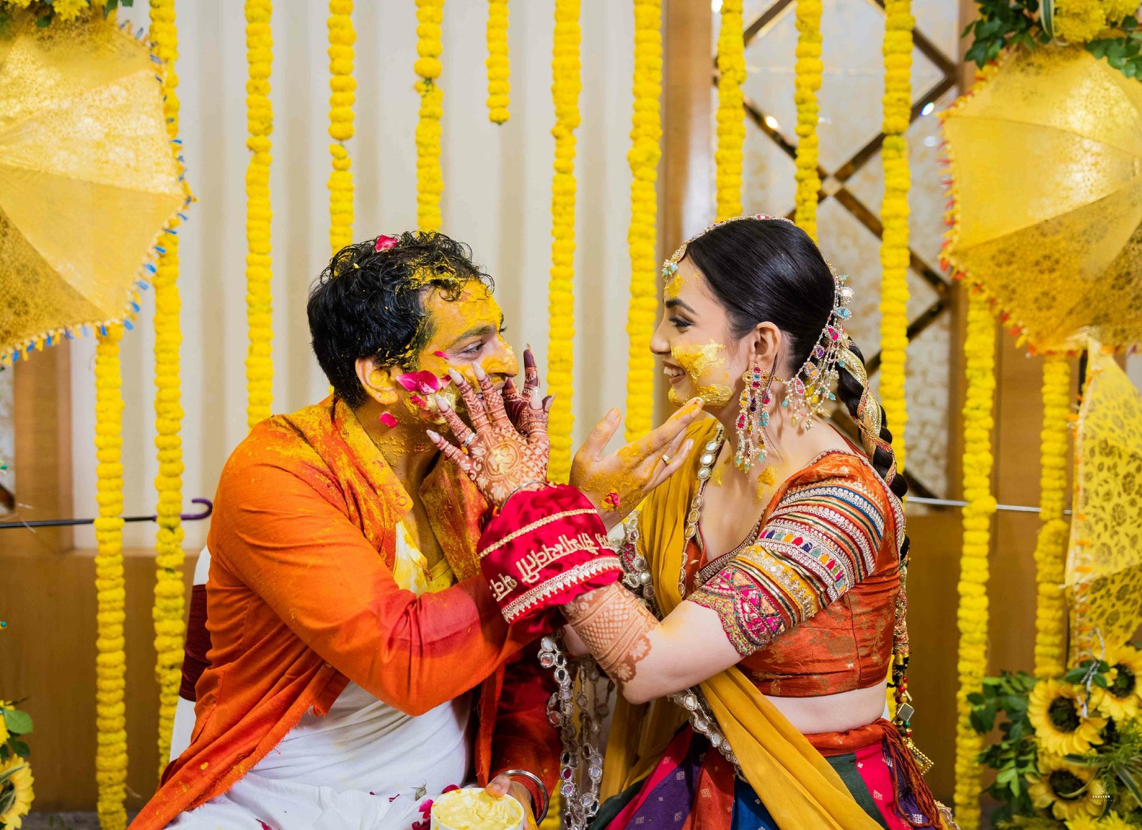 Joyful haldi ceremony moment with bride in yellow outfit during Indian wedding pre-ceremony rituals