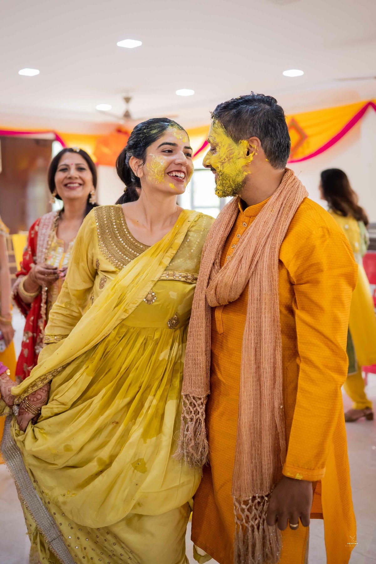 Joyful outdoor haldi ceremony with family members, candid Indian wedding photography by production house