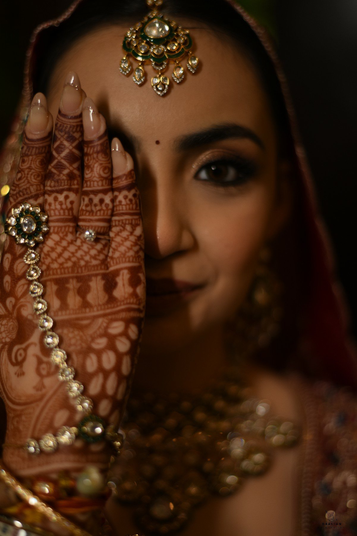 Stunning close-up of Indian bride with mehndi hand, bridal veil and traditional jewellery, wedding photography