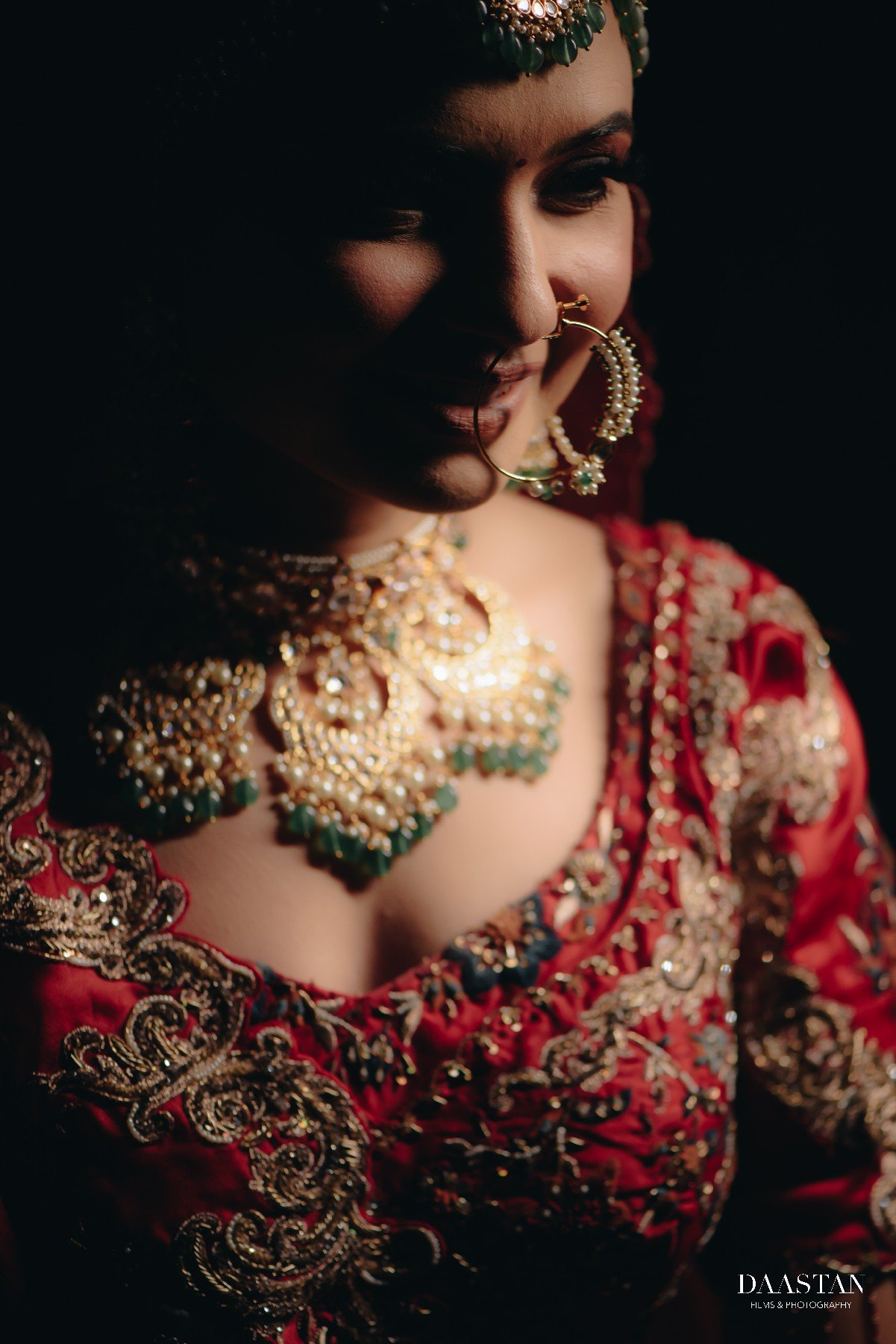 Close-up bridal portrait of Indian bride in red embroidered lehenga with heavy jewellery, cinematic photography