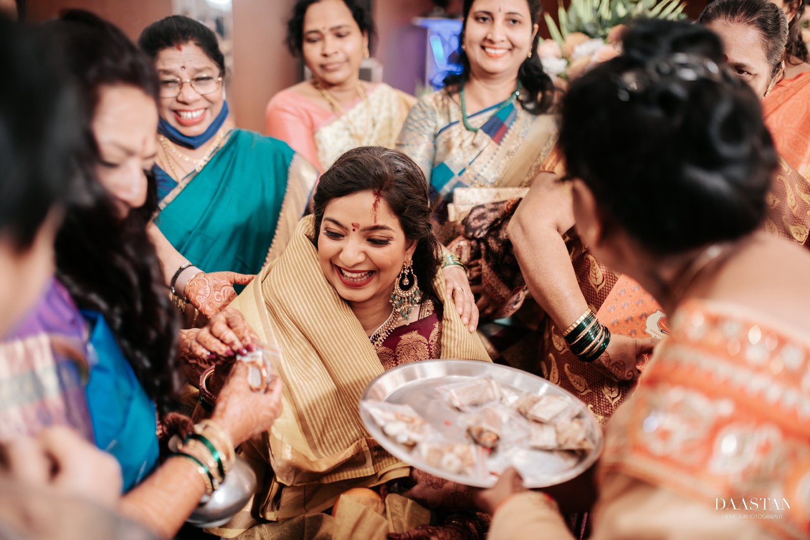 Candid capture of Indian wedding ritual with family gathered around the bride