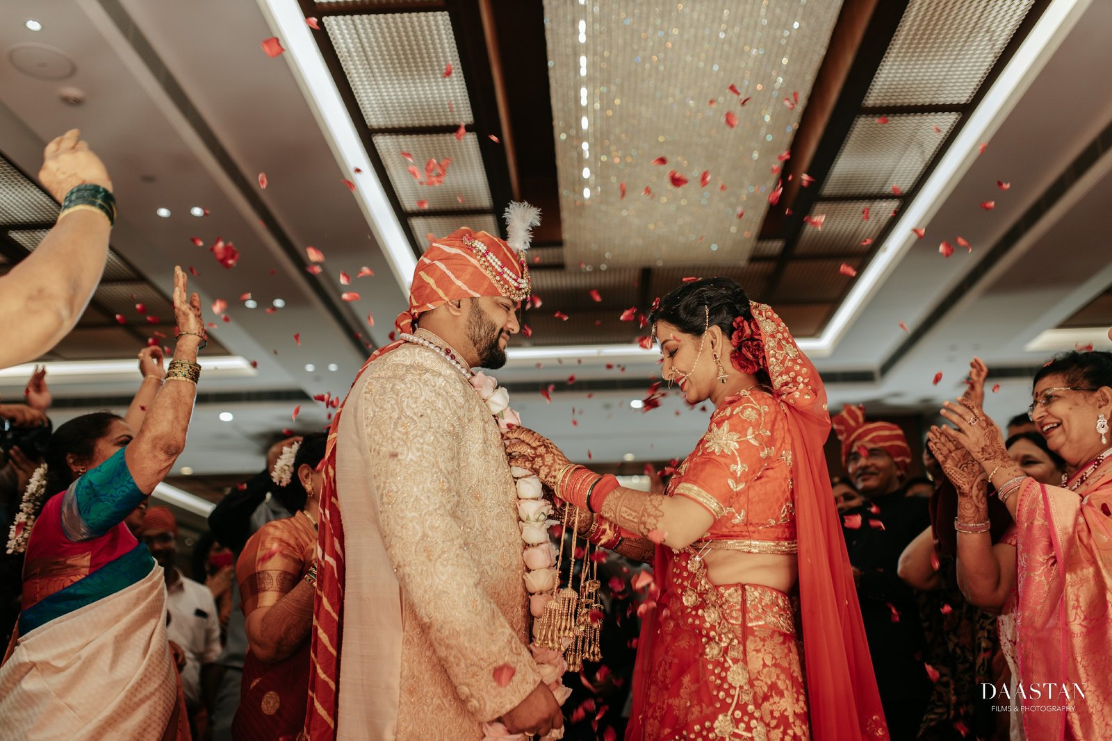 Bride and groom exchanging garlands during jaimala ceremony, Indian wedding production house photography